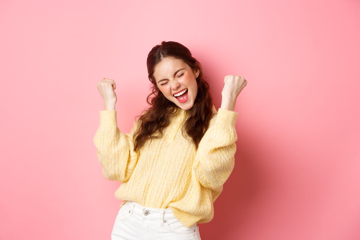 Girl Screams with Joy and Fist Pump, Say Yes, Achieve Goal or Success, Celebrating Achievement, Triumphing and Winning, Standing over Pink Background